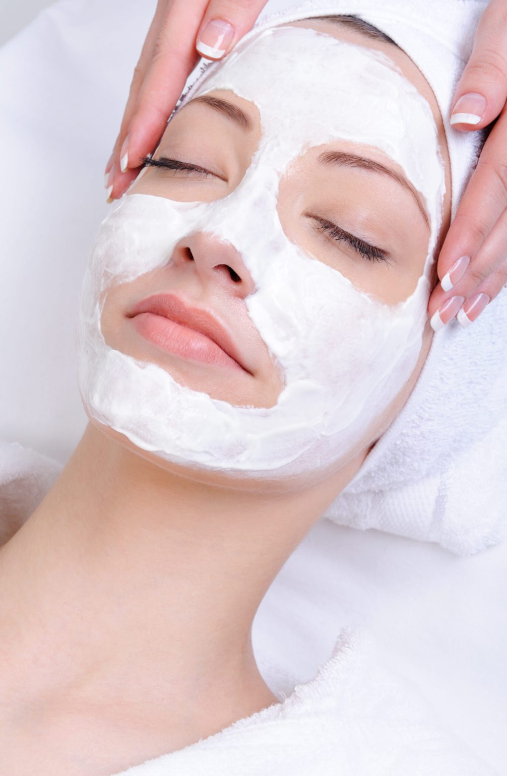 facial mask for young woman in the salon of beauty - close-up